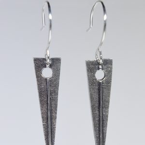 A pair of silver triangular dangling earrings on a grey background.