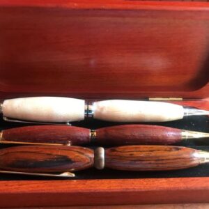 Three wooden pens sit in a wooden case.
