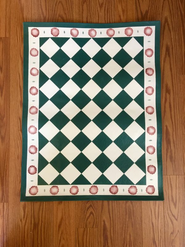 A green and white checkered floorcloth with red spots around the edge.